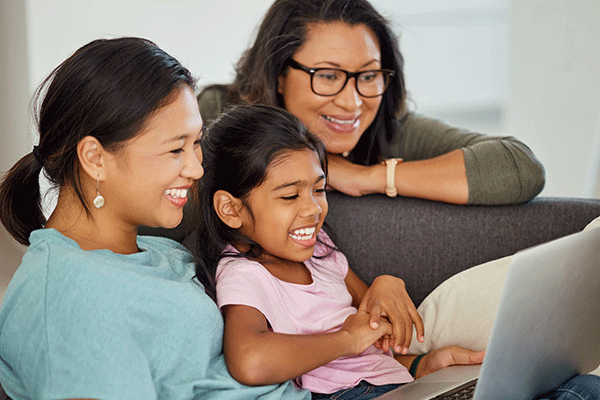 Grandmother, daughter and grand daughter looking at a laptop