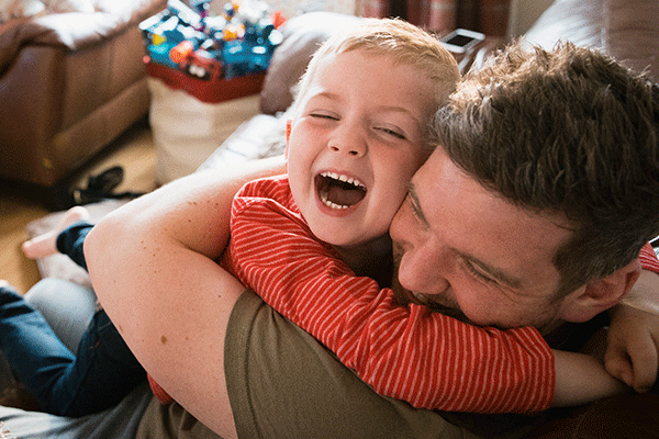 Father and child cuddling and laughing