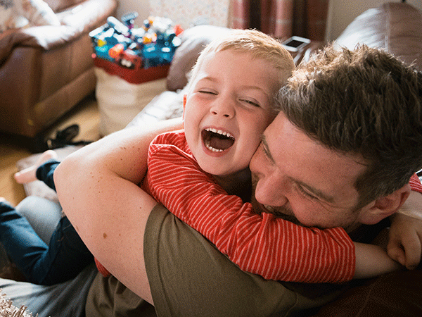 Father and child cuddling and laughing