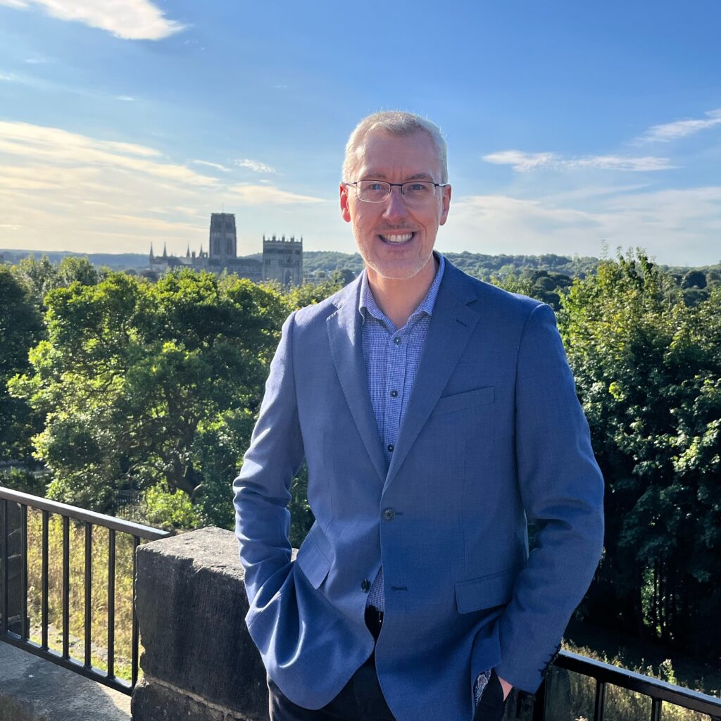 Photograph of Martyn Stenton in front of a view of Durham Cathedral