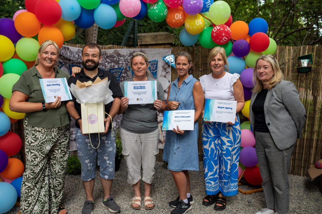 Photograph of six people, several of whom are holding certificates