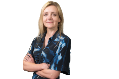 Photograph of Annabel Bates, smiling with arms crossed looking at the camera