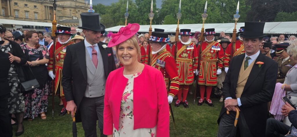 Image of Glenda at the Royal Garden Party in London showing beefeaters in the background